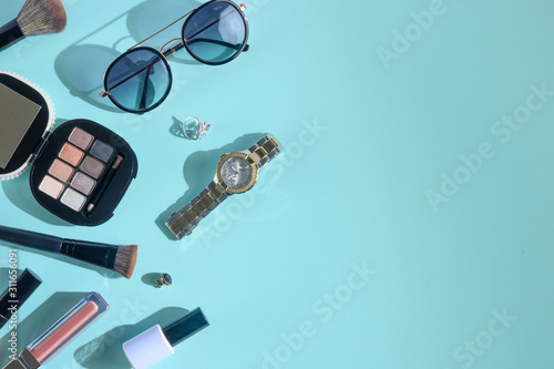 Blogging Beauty Concept. Professional female makeup accessories, watches, bracelet, glasses on a blue background. Female background and fashion. Instagram, women's stuff. Flat Layout. Banner