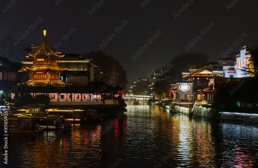 Night view of Qinhuai River and  Fuzimiao from Wende Bridge at Confucius Temple or Fuzimiao, Nanjing, Jiangsu, China, with Kuaiguan Pavilion on left bank and Wenyuan Bridge in middle.