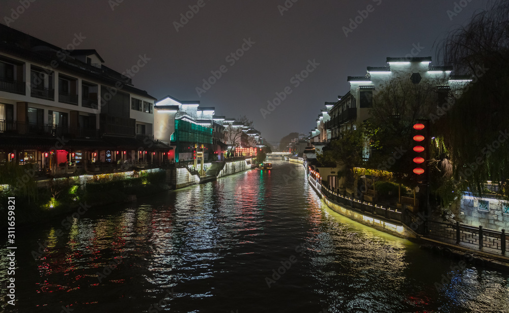 Night scene of Qinhuai River from Wenzheng Bridge with Pingjiang Bridge in middle, historical Taoye Ferry on right bank and traditional buildings on riversides, Nanjing, Jiangsu, China