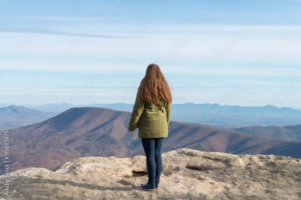 Naklejka premium Young woman on the observation point on McAfee Knob