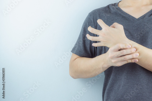 Closeup man holds his wrist pain on white background. Health care and medical concept.