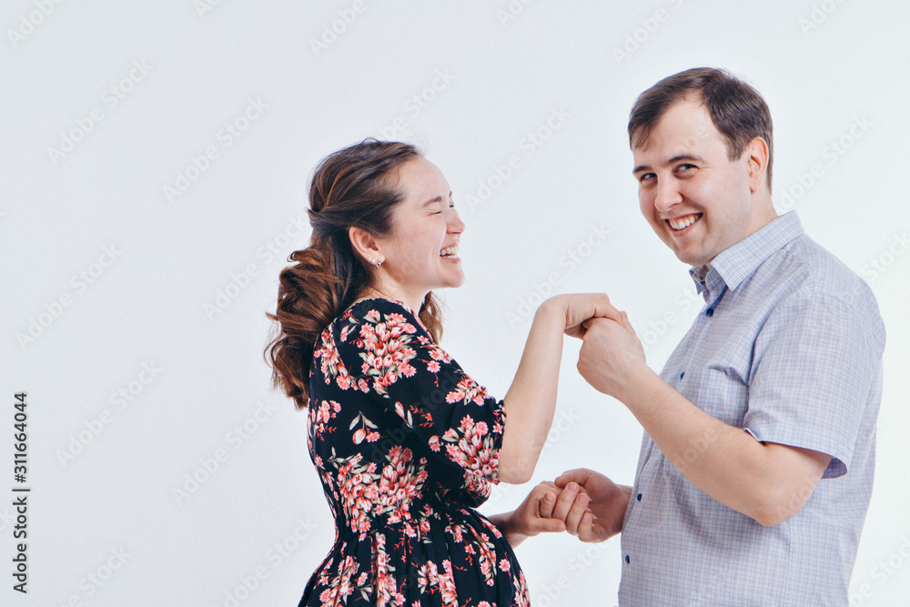 loving couple embracing on a white background. A man and a woman look into each other's eyes. Husband hugs pregnant wife. Valentine's day. February 14 loving couple embracing on a white background. A man and a woman look into each other's eyes. Husband hugs pregnant wife. Valentine's day. February 14