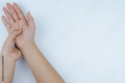 Closeup woman massaging her painful hand on white background. Healthcare concept. Health care and medical concept.