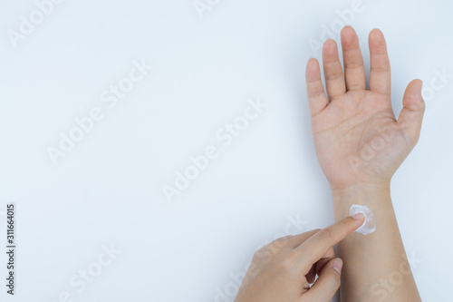 Closeup woman apply pain relief cream on her wrist. Health care and medical concept.
