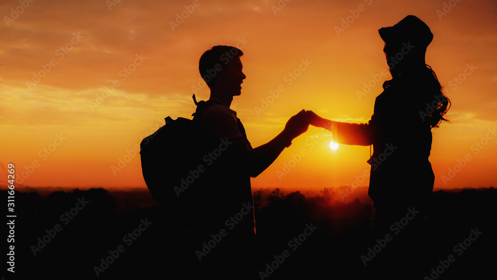 silhouette of loving couple having romantic moment during travel together with sunset sky