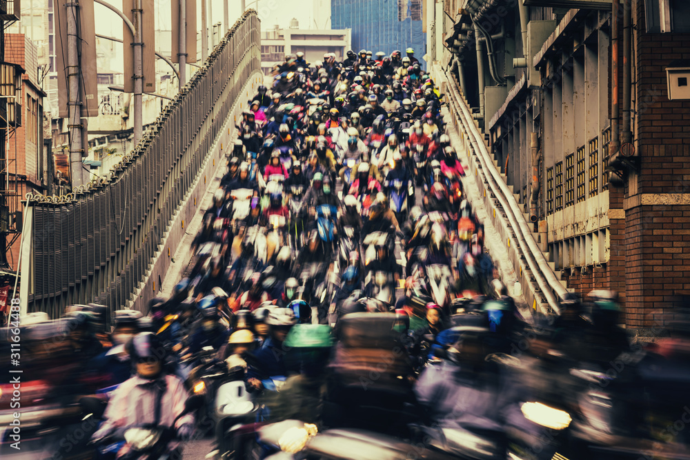 Fototapeta premium Chaos / Tłum ludzi jedzie na skuterze, kręcony z małą prędkością jak wodospad w Tajpej na Tajwanie