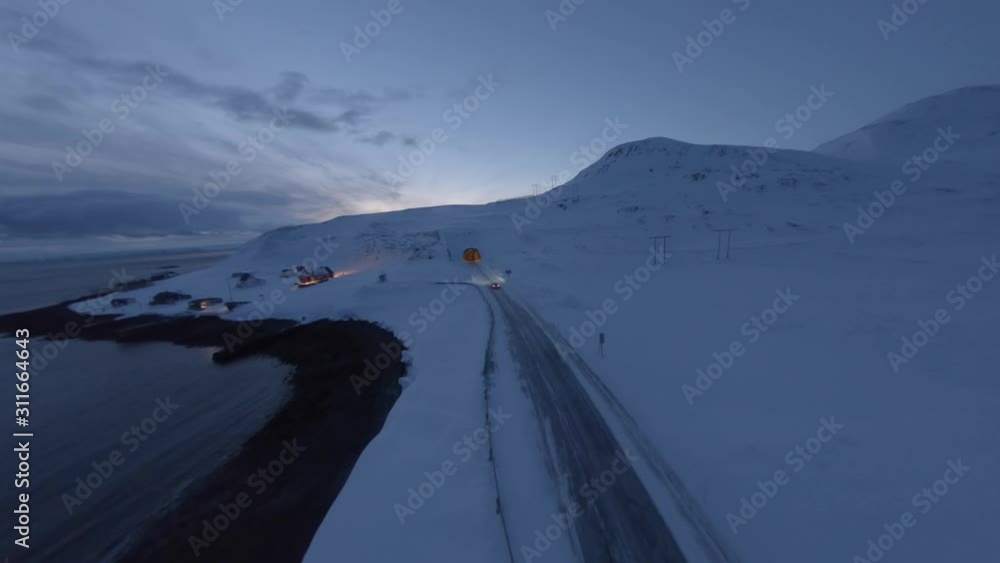 Aerial shot of fast supercar driving through a winter landscape into a tunnel in Norway. Aerial shot of fast supercar driving through a winter landscape into a tunnel in Norway.