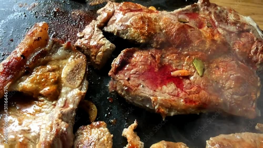 Fresh cow chops beef steaks grilled seasoned on round electric griddle slow-motion zoom alternative green cooking kitchen appliances healthy meal cusine garlic herbs spices delicious electricity Fresh cow chops beef steaks grilled seasoned on round electric griddle slow-motion zoom alternative green cooking kitchen appliances healthy meal cusine garlic herbs spices delicious electricity