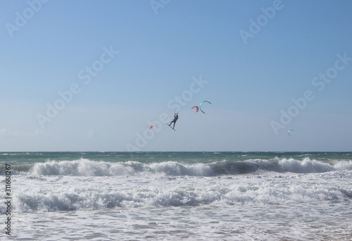 Jumping kitesurfer with blue sky