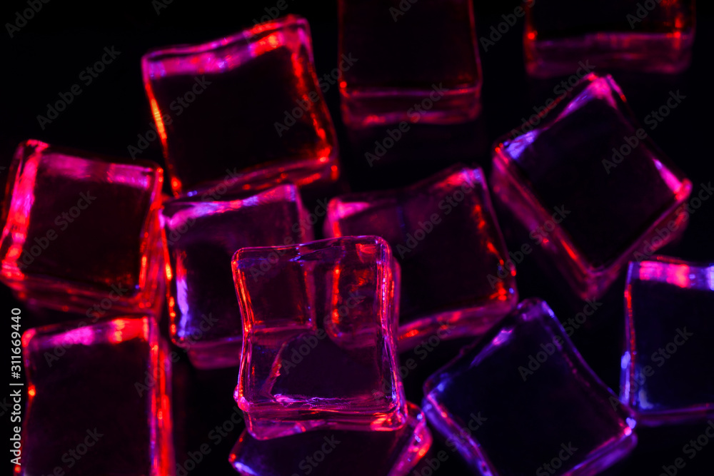 Ice cube. Melting ice cubes with pink and purple backlight on black background. Macro horizontal photography Ice cube. Melting ice cubes with pink and purple backlight on black background. Macro horizontal photography
