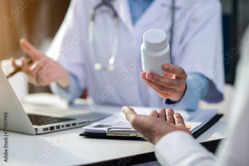 Young female therapist consulting male patient about pills. Doctor prescribing medicine sitting at the desk in the Hospital.