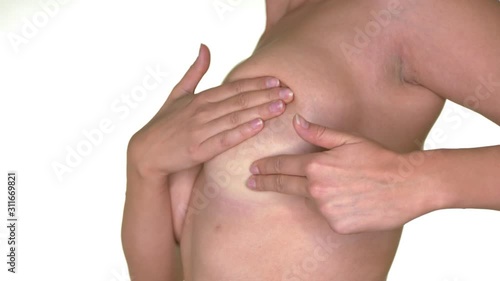 Close-up of a woman's breasts while she is examining for signs of breast cancer. Slow motion, 4k,UHD