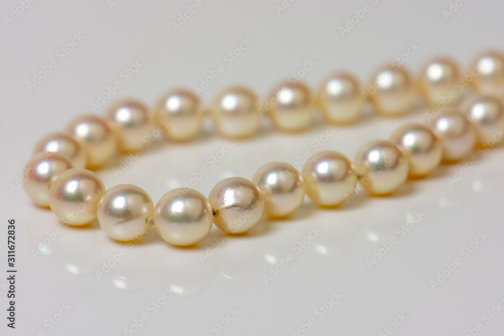 Close up of sphere natural pearl necklace on white background. Selective focus. Close up of sphere natural pearl necklace on white background. Selective focus.