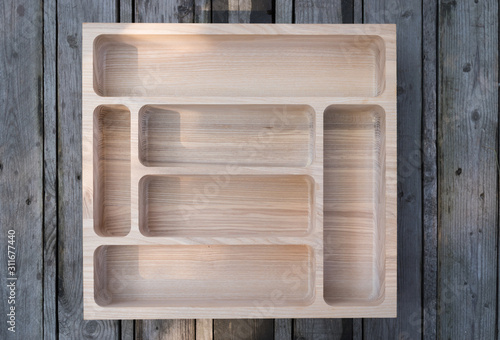 Wooden tray, cutlery organizer on a gray background