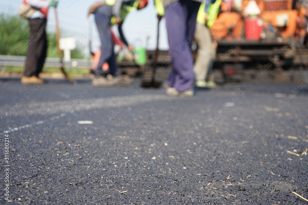 Construction workers on the asphalt road, blurred pictures