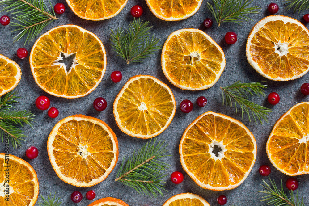 Christmas winter background of dried slices of orange and branches of a Christmas tree and red berries on a dark blue background top view concept. Flat lay Happy New Year composition. Xmas mockup. Christmas winter background of dried slices of orange and branches of a Christmas tree and red berries on a dark blue background top view concept. Flat lay Happy New Year composition. Xmas mockup.