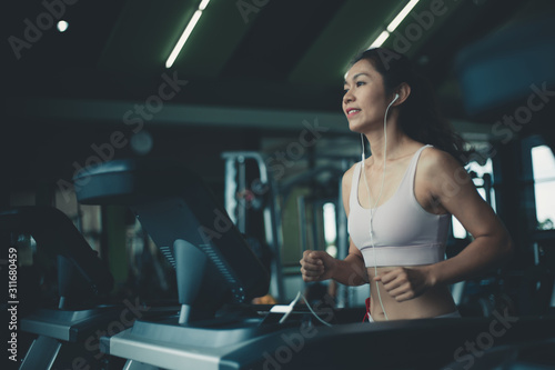 Asian young fitness woman on the treadmill in the gym.