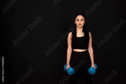 Strong looking girl doing sports on a black background