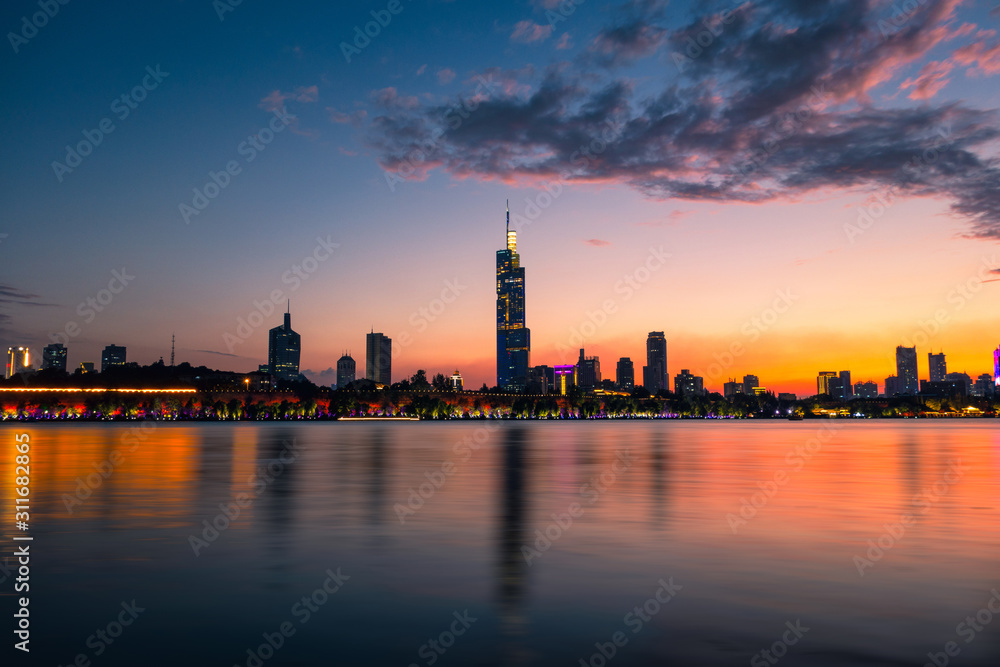 Naklejka premium Skyline of Nanjing City by Xuanwu Lake at Sunset