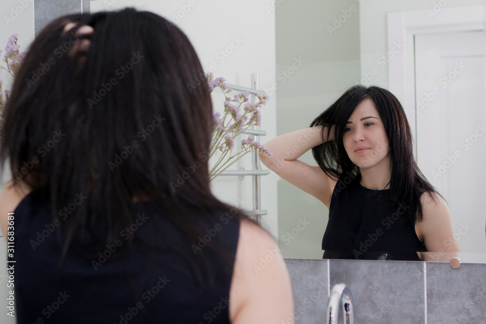 Fototapeta premium Sexy young woman. Seductive young woman with long hair posing in the bathroom.
