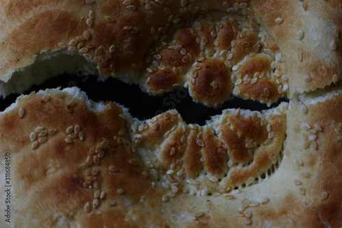 roken bread cake with sesame seeds on a dark background photo