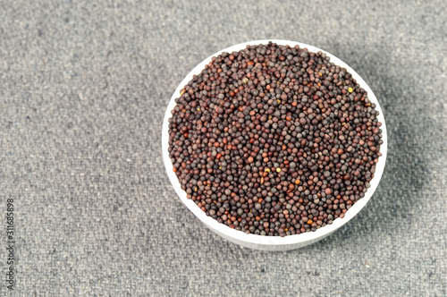 Brown Mustard Seeds in bowl on sackcloth