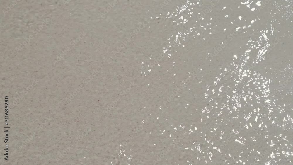 Top down view and closeup of Sea wave water ripple on white soft sand at the beach, look clean and clear for background footage video Top down view and closeup of Sea wave water ripple on white soft sand at the beach, look clean and clear for background footage video