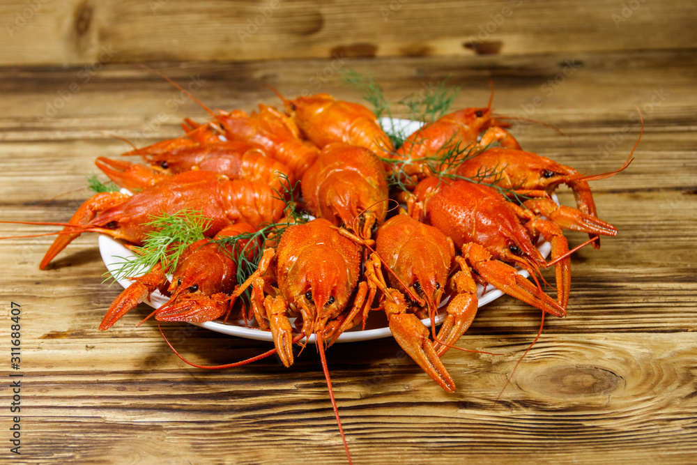 Boiled crayfish in plate on wooden table Boiled crayfish in plate on wooden table