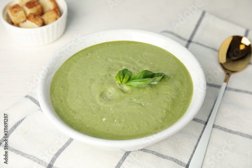 Delicious broccoli cream soup served on white table