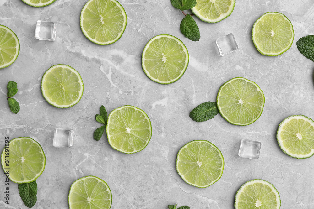 Flat lay composition with slices of fresh juicy limes on marble table Flat lay composition with slices of fresh juicy limes on marble table