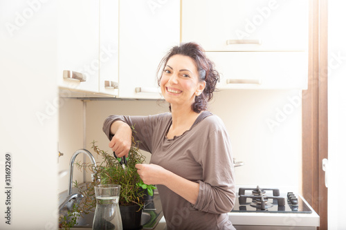 Happy woman cutting rosemary