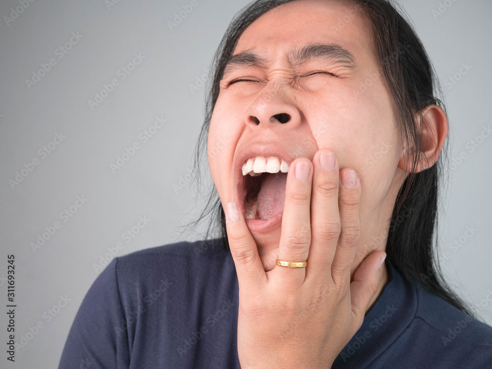 Woman catching on cheek because she have a toothache. Healthcare and medical concepts. Woman catching on cheek because she have a toothache. Healthcare and medical concepts.