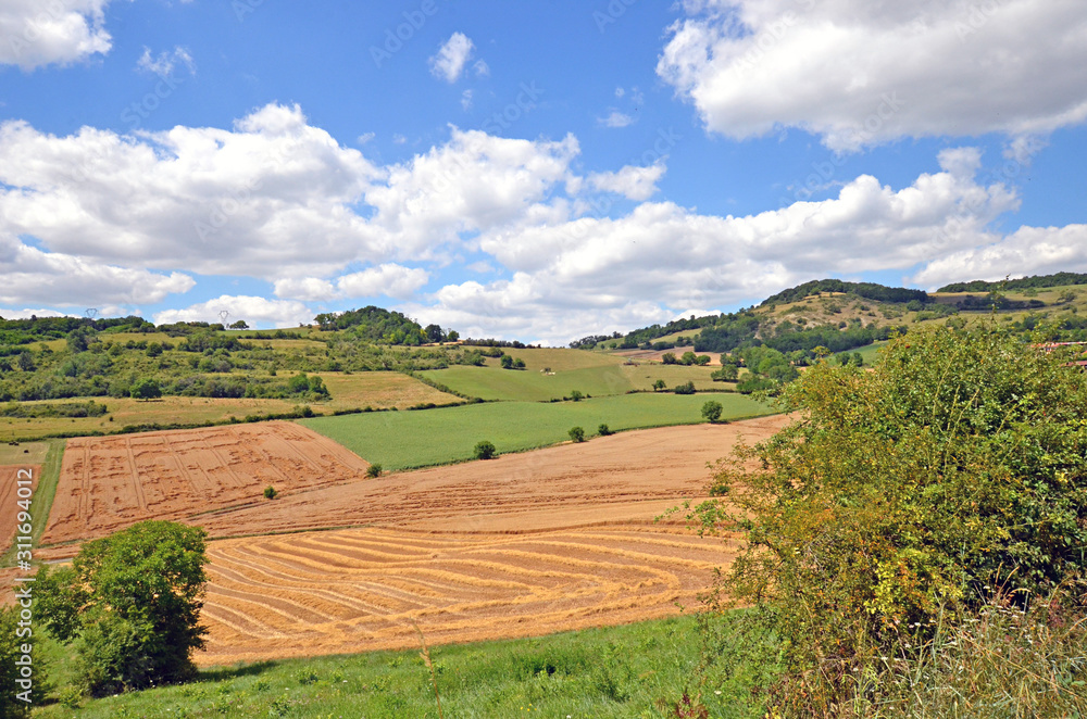 Beautiful rural landscape with blue sky, spectacular clouds and wheat fields in Auvergne region in France