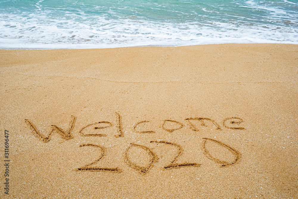 Fototapeta premium Welcome 2020 written in the sand- New Year’s concept