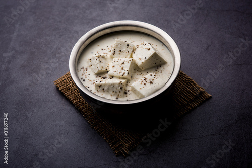 Paneer Dum Kali Mirch / Kalimirch, prepared in a white creamy gravy and black pepper powder sprinkled over it. served in a bowl. Selective focus photo