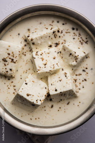 Paneer Dum Kali Mirch / Kalimirch, prepared in a white creamy gravy and black pepper powder sprinkled over it. served in a bowl. Selective focus photo