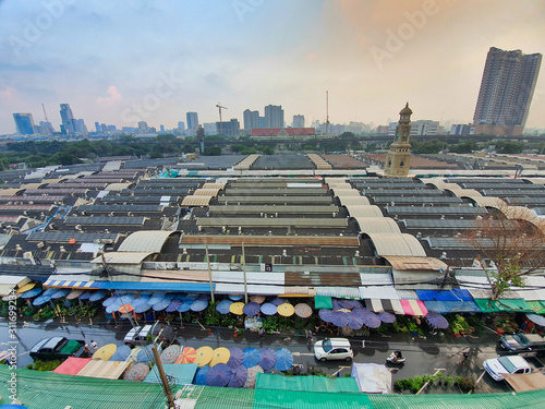 Photography Top view of the famous Jatujak or Chatuchak weekend Sunday market, The view of hundreds stall roof and clock tower, wide-angle lenses, main meeting point in Bangkok, Thailand