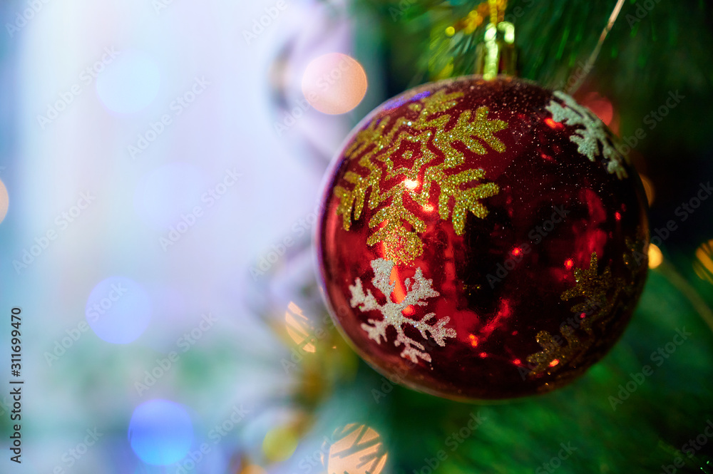 Fototapeta premium New Year and Christmas concept. Festive photo of decorations for the Christmas tree in the New Year holiday on a background of lights