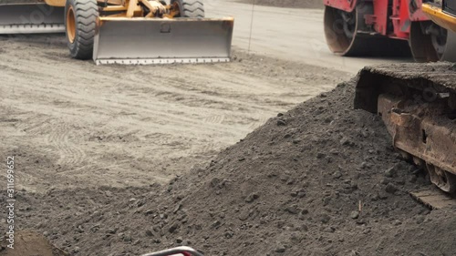 Construction machinery works at a construction site. Road construction. Bulldozer bucket close-up. Construction site work