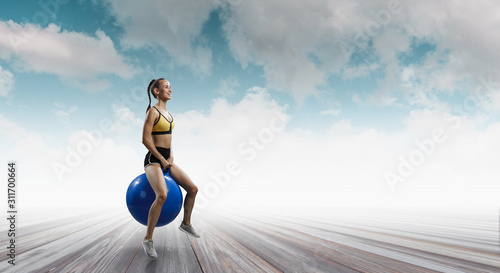 Sporty woman on fitness ball. Mixed media