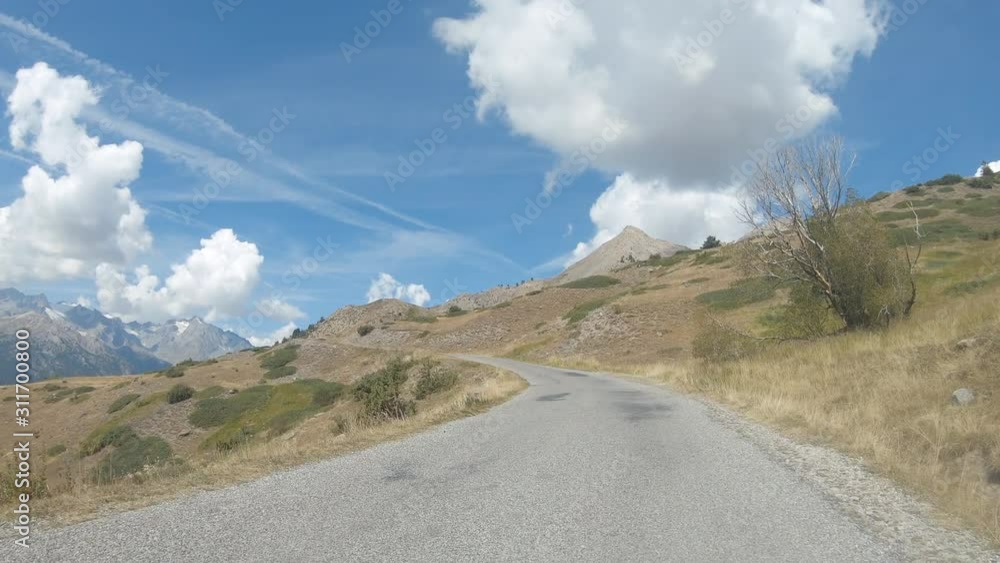 Vehicle point of view shot while driving on the road climbing to the mountain pass Granon in Massif des Cerces in the French Alps. The environmental sound is present. Vehicle point of view shot while driving on the road climbing to the mountain pass Granon in Massif des Cerces in the French Alps. The environmental sound is present.