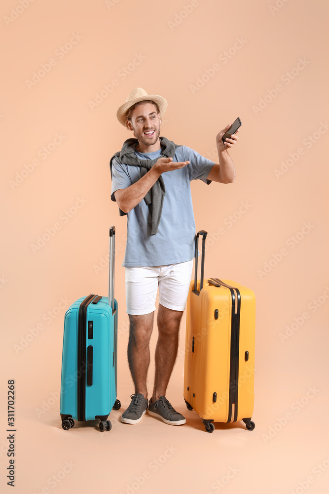 Young tourist with luggage on color background Young tourist with luggage on color background