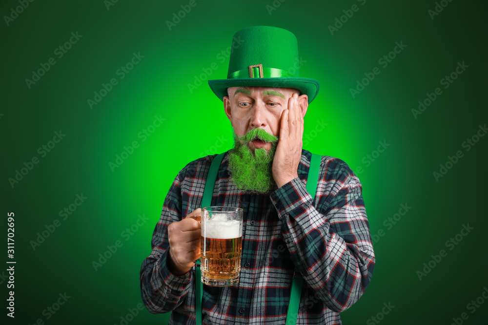 Funny mature man with glass of beer on dark background. St. Patrick's Day celebration Funny mature man with glass of beer on dark background. St. Patrick's Day celebration