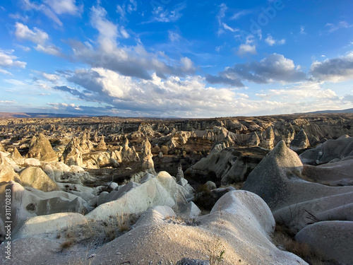 View of a valley filled with ancient rock formations. Blue sky, white clouds. Landscape. Cappadocia, Turkey. November 5, 2019.