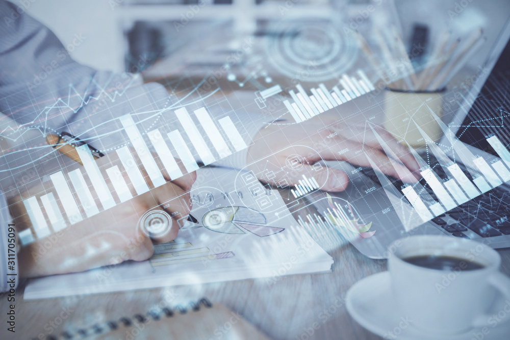 Multi exposure of stock market graph with man working on laptop on background. Concept of financial analysis.