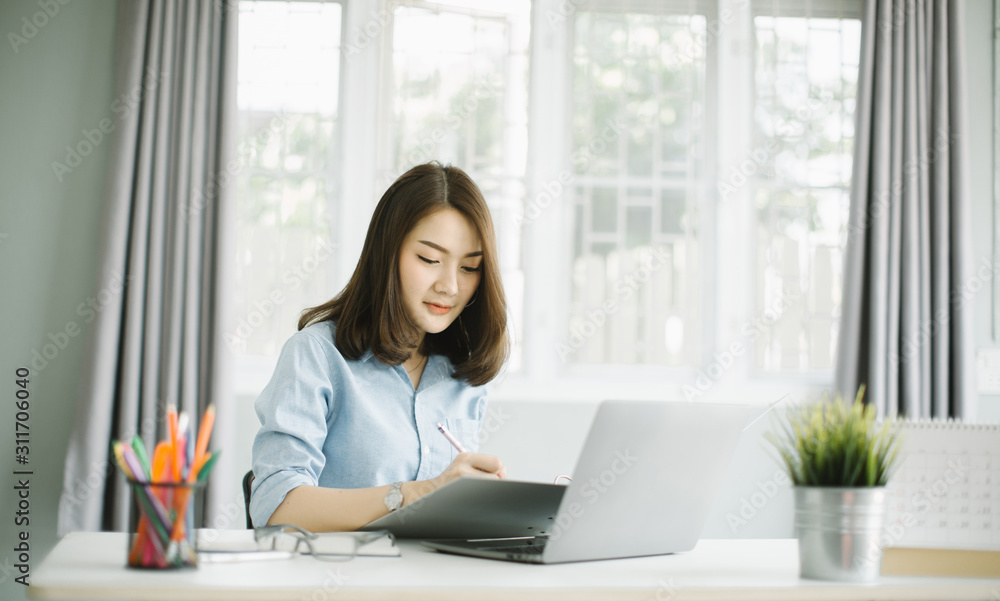 businesswoman using laptop while doing some paperwork at the office. businesswoman using laptop while doing some paperwork at the office.