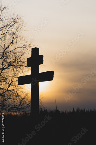 Religious cross at sunset. sun goes down behind the cross. faith concept