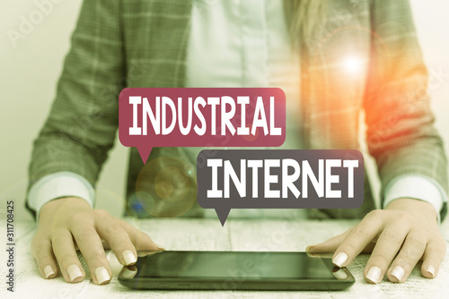Word writing text Industrial Internet. Business photo showcasing use of the internet of things in industrial sectors Business woman sitting with mobile phone on the table