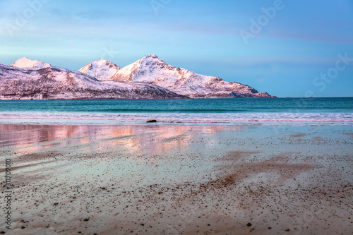 Amazing sunrise with amazing magenta color over sand beach. Tromso, Norway . Polar night. long shutter speed