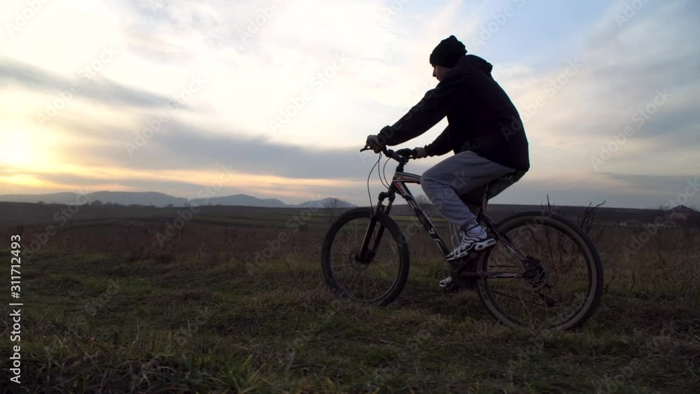 19.12.2019.Ukraine.Chernivtsi.Young guy cycling on a dirt road. Sunset 19.12.2019.Ukraine.Chernivtsi.Young guy cycling on a dirt road. Sunset